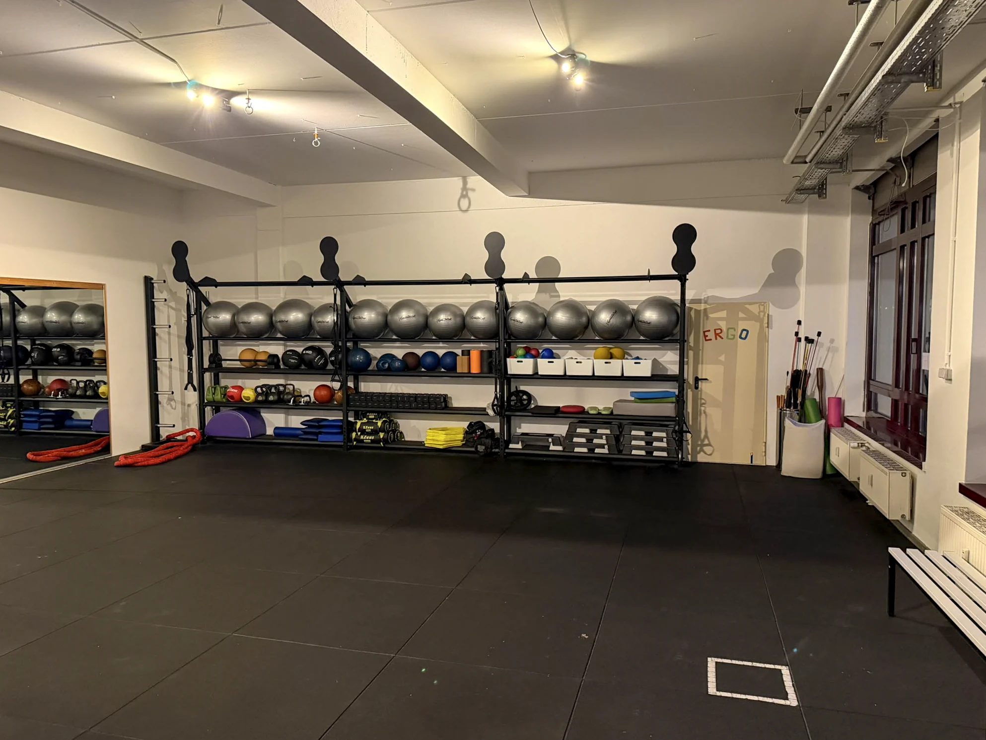Kursraum mit freien Trainingsflächen und Kleingeräten in der Sport-REHA Berlin