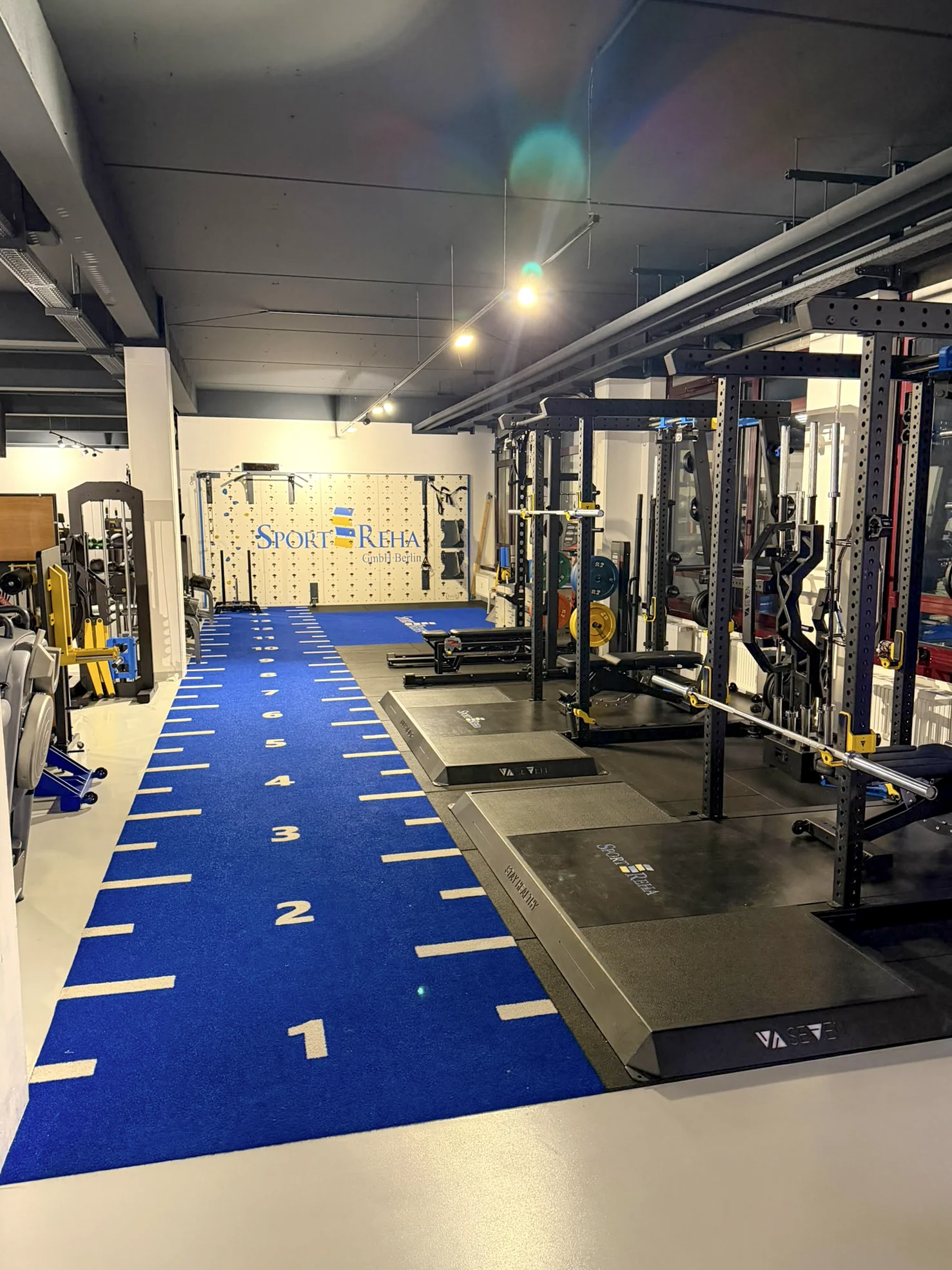 Blaue Trainingsbahn zwischen den Trainingsgeräten in der Sport-REHA Berlin
